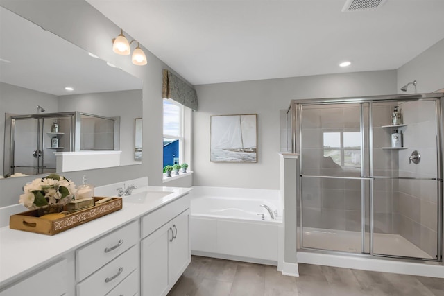 bathroom featuring vanity and shower with separate bathtub