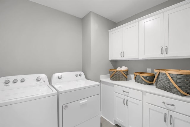 clothes washing area with washer and dryer and cabinets