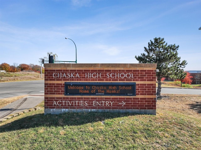 community / neighborhood sign featuring a lawn