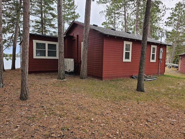 view of side of home with ac unit and a yard