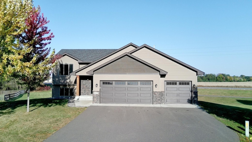 1620 18th Ct SE, Cambridge, MN 55008 - view of front facade featuring driveway, a front yard, stone siding, and a garage