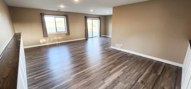 unfurnished room with dark wood-type flooring