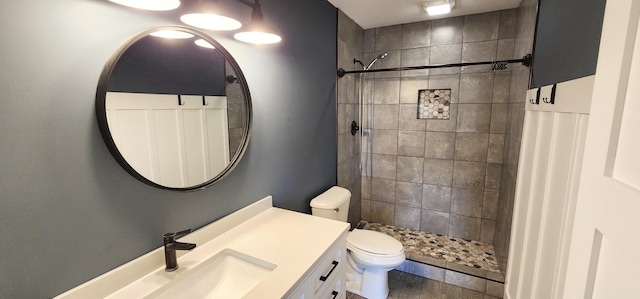 bathroom with vanity, tiled shower, hardwood / wood-style flooring, and toilet