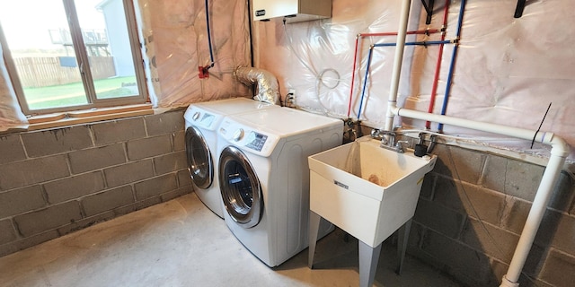 clothes washing area featuring independent washer and dryer and sink