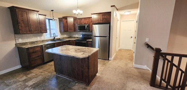 kitchen with sink, a center island, hanging light fixtures, stainless steel appliances, and lofted ceiling