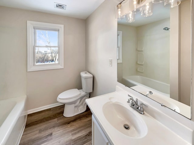 full bathroom with visible vents, toilet, vanity, wood finished floors, and baseboards