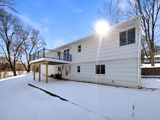 snow covered property with central AC and a wooden deck