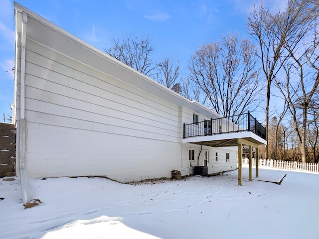 view of snow covered exterior with fence