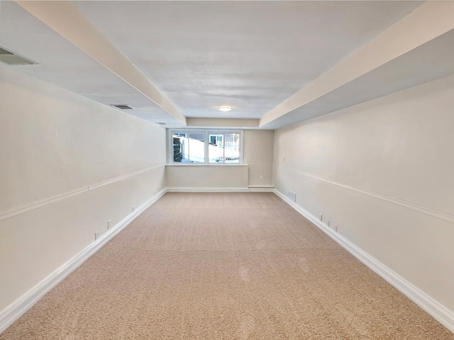 spare room featuring carpet floors, visible vents, and baseboards