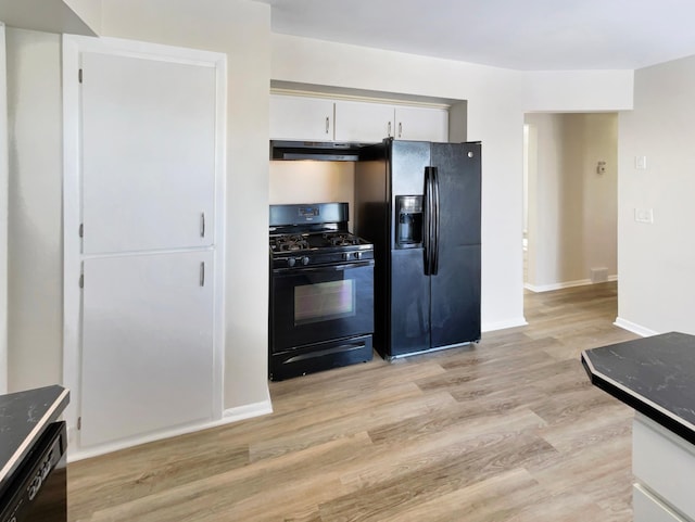 kitchen featuring black appliances, dark countertops, white cabinetry, and under cabinet range hood