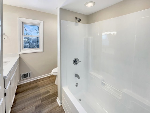 full bathroom featuring visible vents, toilet, vanity, wood finished floors, and baseboards