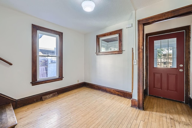 foyer featuring a textured ceiling and light wood-type flooring