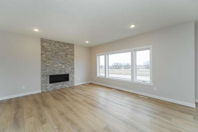 unfurnished living room with a fireplace and light hardwood / wood-style flooring