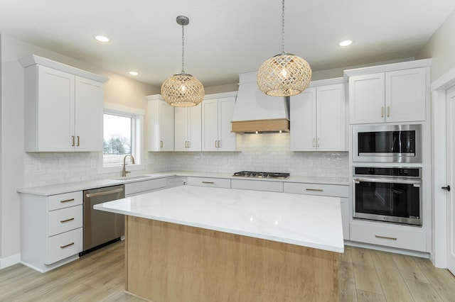 kitchen featuring custom range hood, a center island, stainless steel appliances, and white cabinetry