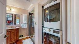22735 Hickory Rd, Lanesboro, MN 55949 - laundry room with stacked washing machine and dryer and dark wood-type flooring