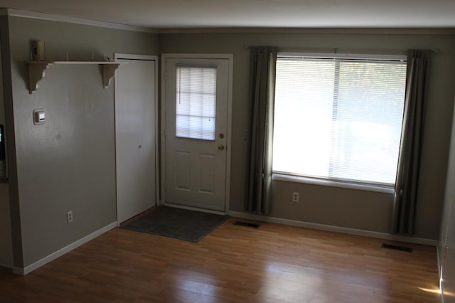 foyer with ornamental molding and hardwood / wood-style flooring