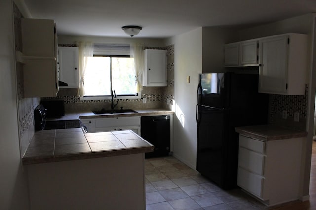 kitchen featuring black appliances, sink, decorative backsplash, and white cabinets