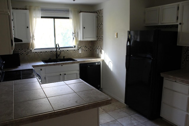 kitchen with tasteful backsplash, black appliances, sink, and white cabinets