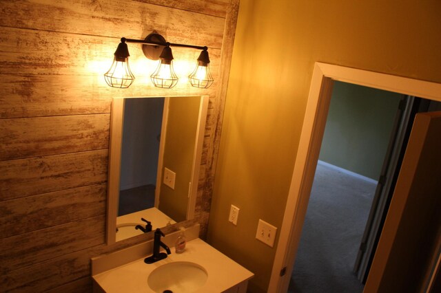 bathroom with vanity and wood walls