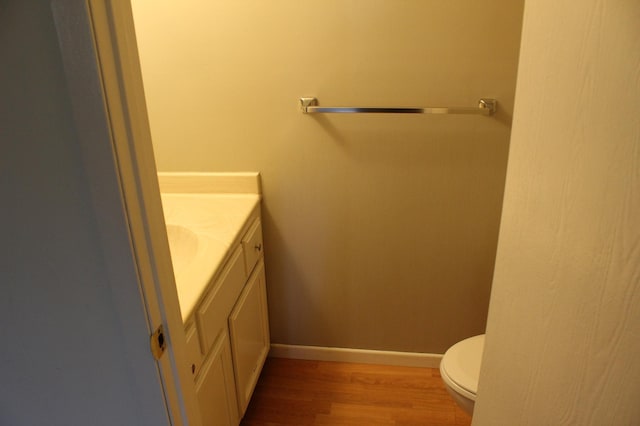 bathroom with vanity, hardwood / wood-style floors, and toilet