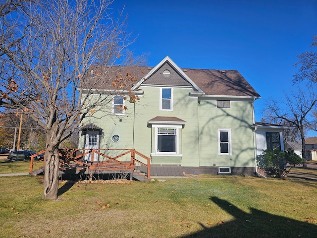 back of property featuring a wooden deck and a lawn