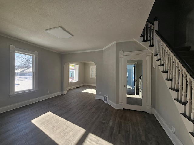 interior space featuring dark wood-style floors, arched walkways, visible vents, and a healthy amount of sunlight