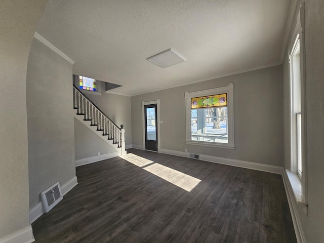 entryway with dark wood finished floors, stairway, and visible vents