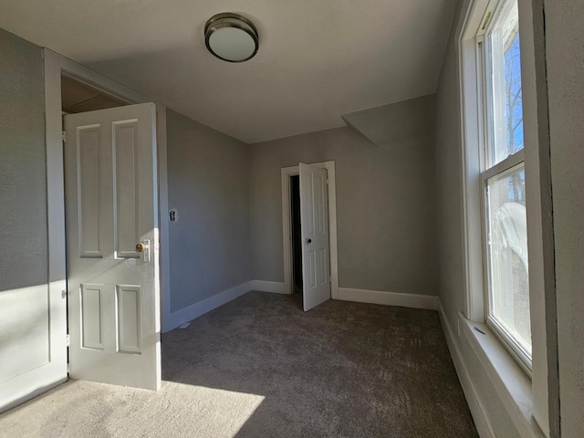 spare room featuring carpet flooring, plenty of natural light, and baseboards