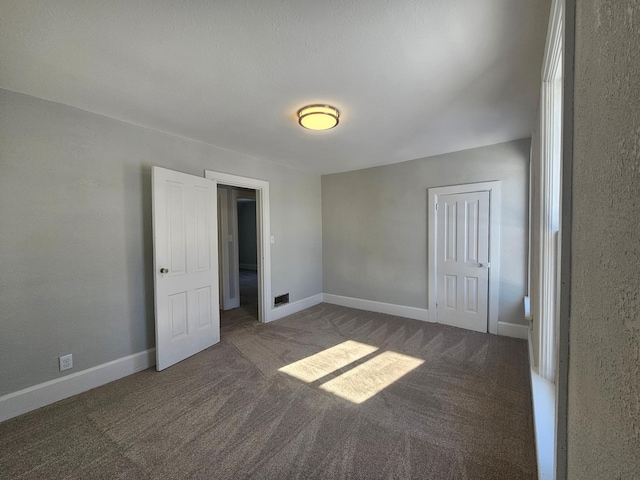 unfurnished bedroom featuring baseboards and carpet flooring