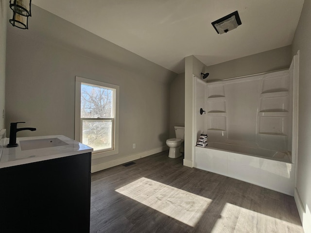 full bath featuring wood finished floors, visible vents, a sink, bathtub / shower combination, and toilet