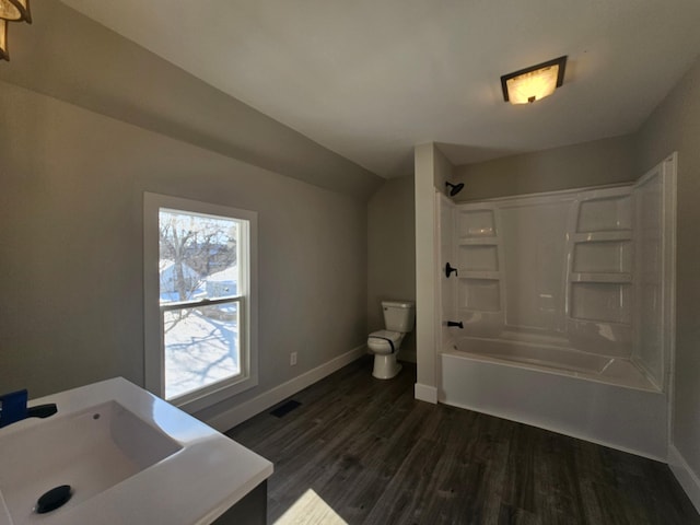 full bathroom with wood finished floors, visible vents, baseboards, shower / washtub combination, and toilet