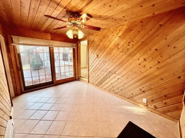 spare room with wood ceiling, light tile patterned floors, wooden walls, and ceiling fan