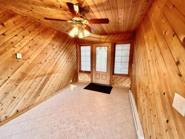 interior space with light tile patterned flooring, wood ceiling, wooden walls, and ceiling fan