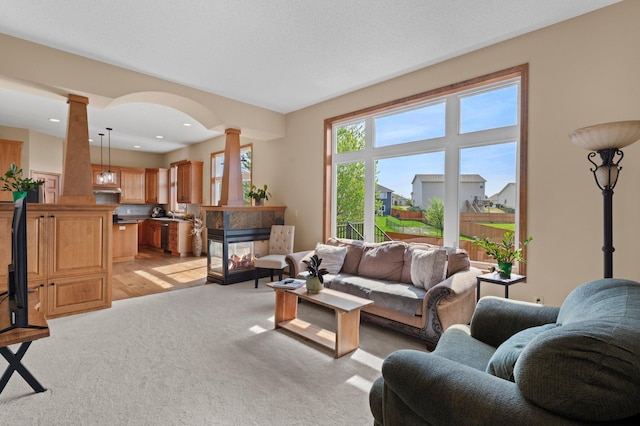 214 15th Ave SE, Lonsdale, MN 55046 - living area with ornate columns, a multi sided fireplace, and light colored carpet