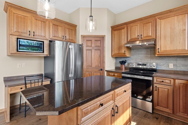 214 15th Ave SE, Lonsdale, MN 55046 - kitchen featuring under cabinet range hood, appliances with stainless steel finishes, decorative backsplash, dark wood-style flooring, and pendant lighting
