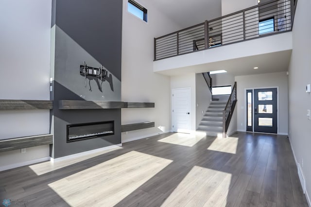 entrance foyer featuring wood-type flooring and a towering ceiling