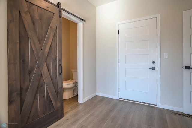 bathroom with hardwood / wood-style flooring and toilet