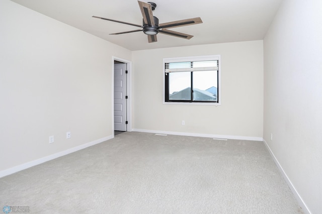 spare room with light colored carpet and ceiling fan