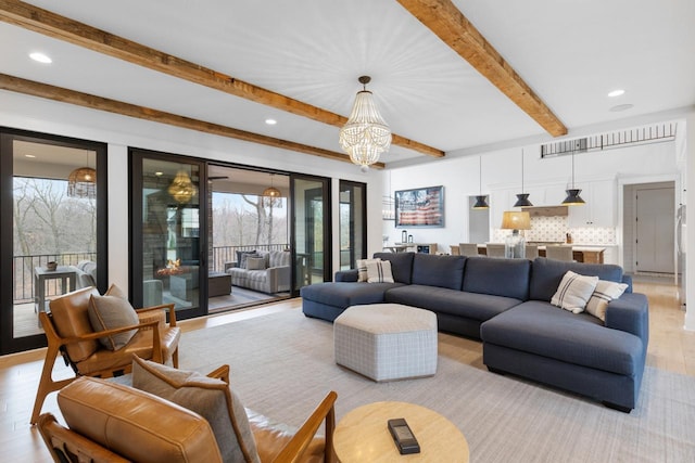 living room with beamed ceiling, a chandelier, and light hardwood / wood-style flooring