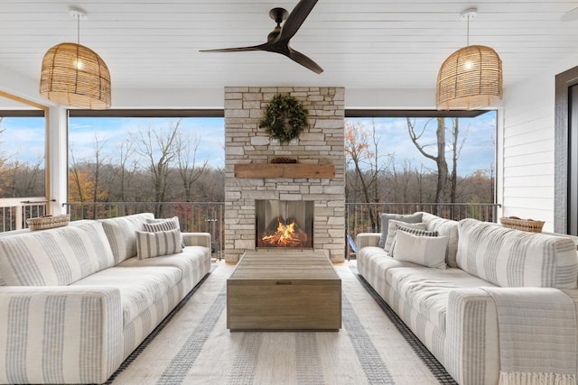 living room featuring ceiling fan and an outdoor stone fireplace