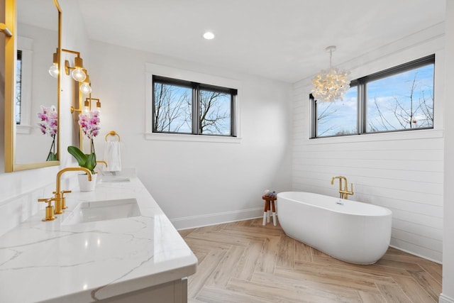 bathroom featuring a washtub, vanity, parquet floors, and a notable chandelier