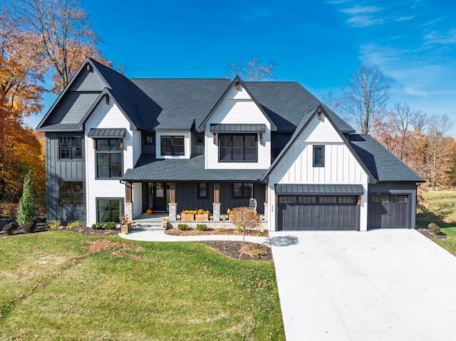 modern farmhouse style home with covered porch, a front lawn, board and batten siding, and a garage