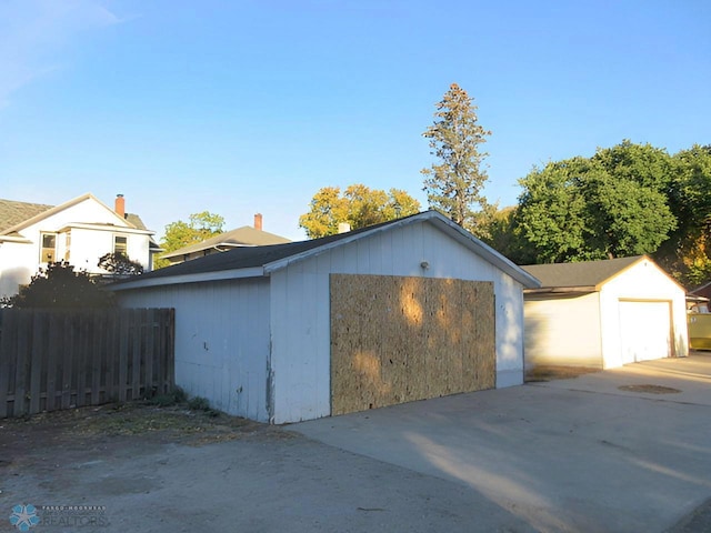 exterior space featuring a garage and an outbuilding