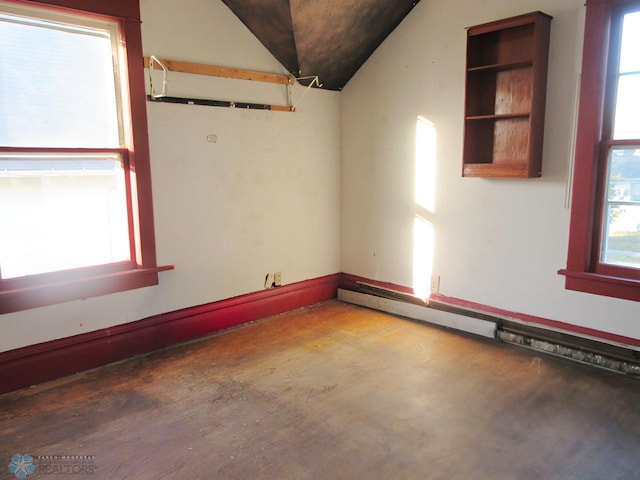 spare room featuring concrete floors, lofted ceiling, and a baseboard heating unit