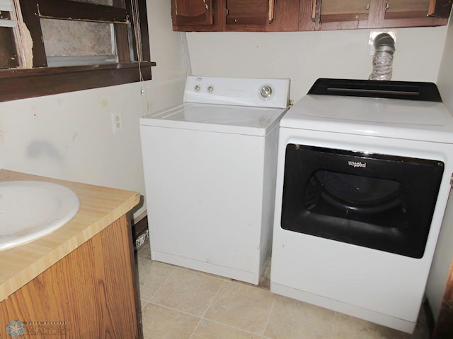 laundry area with sink, independent washer and dryer, and light tile patterned floors