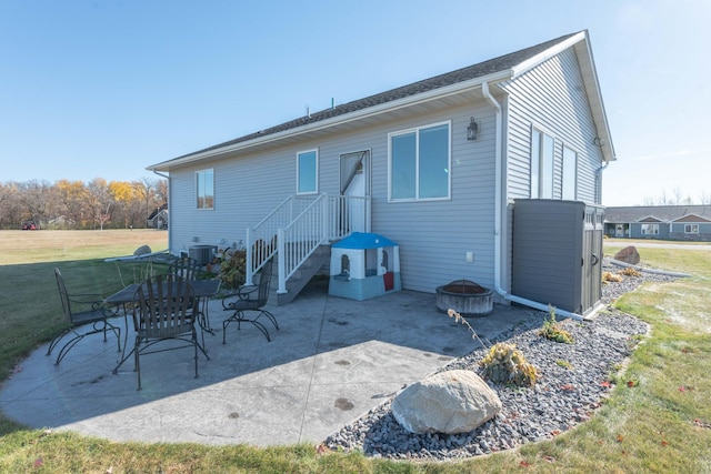 back of house featuring central air condition unit, a patio area, and a lawn