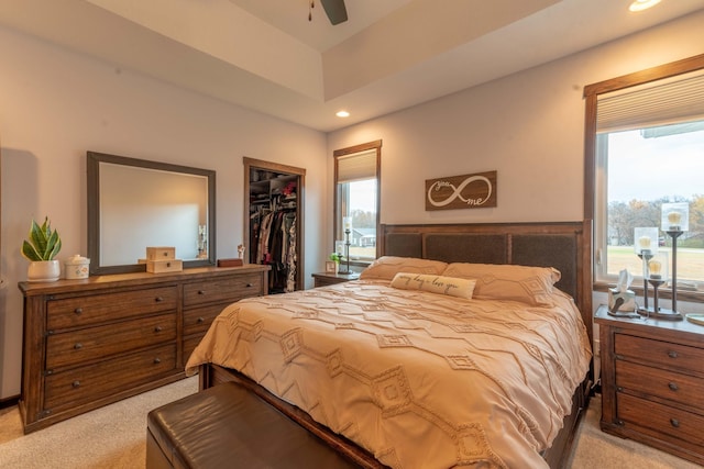 carpeted bedroom with a spacious closet, ceiling fan, a closet, and multiple windows