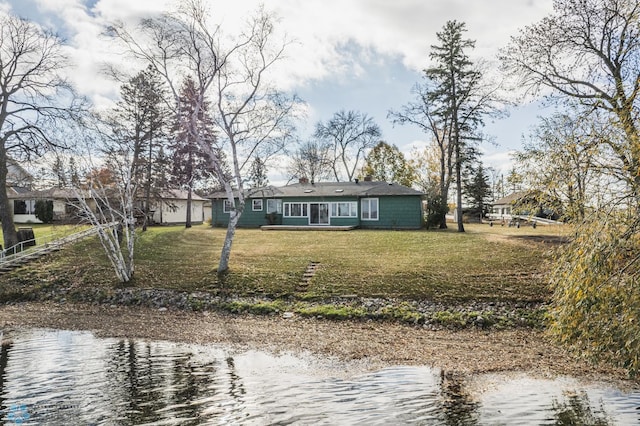 rear view of house featuring a yard and a water view