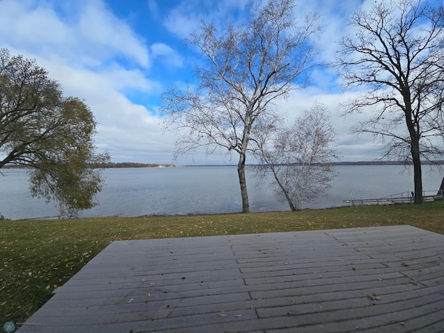 deck with a water view and a lawn