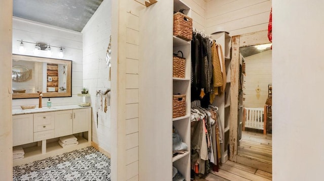 bathroom featuring vanity, wood-type flooring, and lofted ceiling